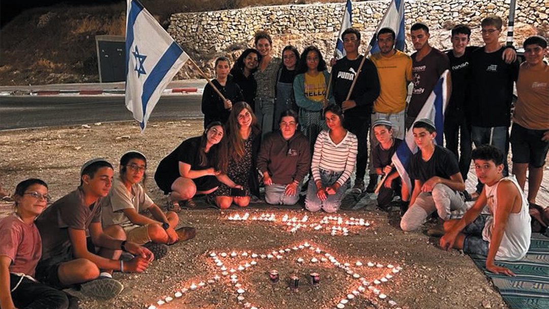 The community of Bet Hagai mourns the loss of Batsheva Nigri. Local teens create a Star of David out of memorial candles to symbolise their determination to hold on to the land regardless of the danger.